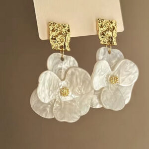 Close-up of vintage acrylic flower petal pendant earrings with alloy flower dangles against a neutral background